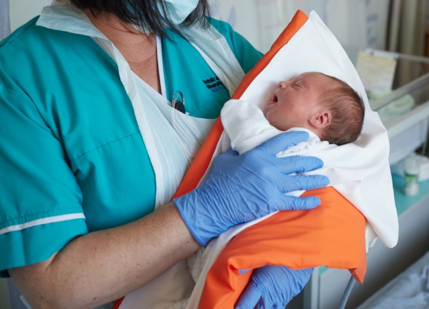 A midwife holds a newborn baby